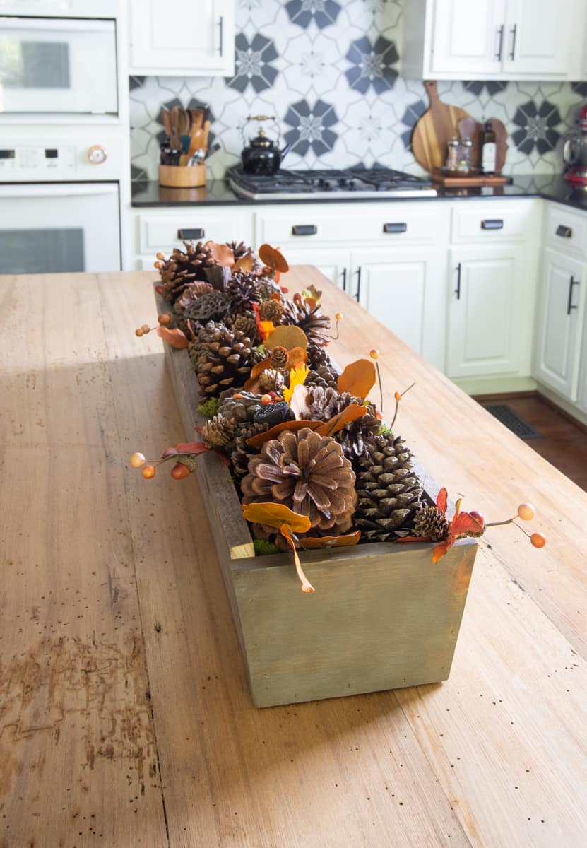 Fall centerpiece with pine cones and leaves